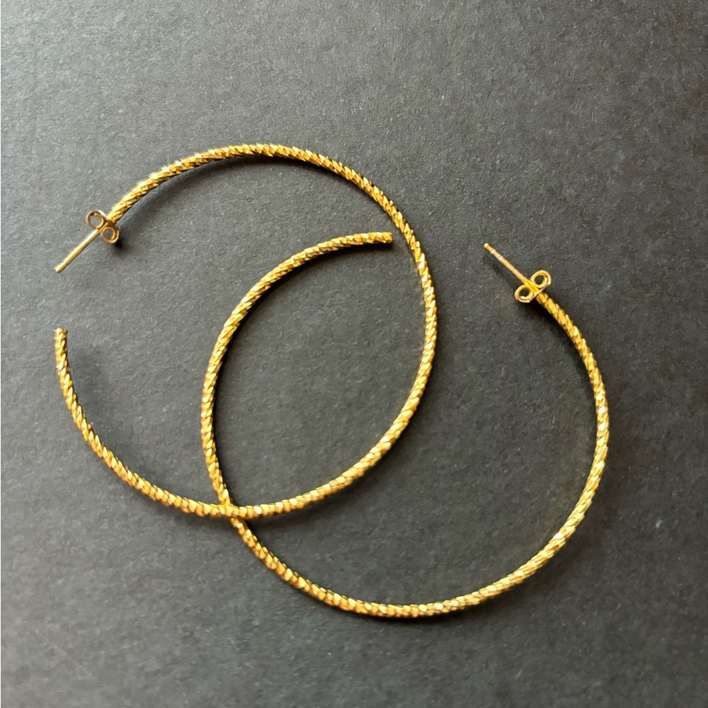 Large 2” gold tone diamond cut hoop pierced earrings.